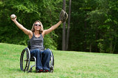 坐轮椅的女人在绿地上玩接球