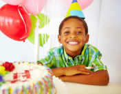 生日聚会上，小男孩在蛋糕前微笑