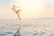 年轻的亚洲男子在日落海滩做瑜伽运动