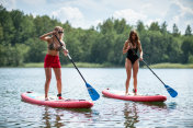 在湖岸附近用站立式桨板进行娱乐活动