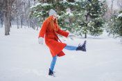 女人在冬天的公园玩雪