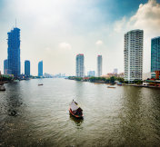 泰国曼谷湄南河上有游船和背光天际线