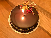巧克力生日蛋糕和点燃的蜡烛
