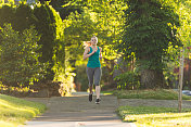 一个阳光明媚的早晨，女跑步者在公园里慢跑