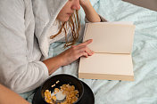 一个女人一边看书一边吃牛奶玉米片，书的模型