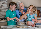 奶奶一边烘烤饼干，一边和她的孙子们共度美好时光