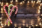圣诞背景:质朴的木桌上放着三根拐杖糖