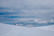 冬季，女性高山攀登者在山顶观赏美丽的风景