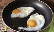 在不粘锅里用油煎蛋的形象
