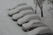 在寒冷的冬天，停着的汽车被厚厚的积雪覆盖着