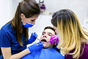 治疗病人牙齿的牙医和牙科助手