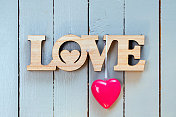 情人节装饰(爱的标志和一颗红心)在一个木制的背景