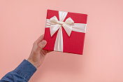 男人赠送或接受礼盒甜粉色背景
