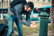 游客饮用公共喷泉的水