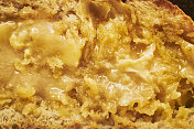 近距离观察烤面包与融化的黄油和蜂蜜的表面。