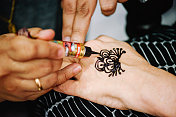 艺术家在手上绘制指甲花纹身