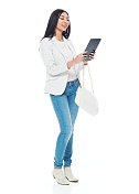 美丽的拉美女性穿着夹克和牛仔裤-使用平板电脑