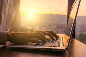 一个人在日落时使用笔记本电脑