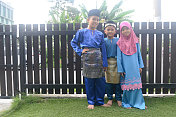 在开斋节期间，马来西亚儿童在家里穿着传统服装