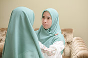 一个穆斯林母亲戴着她女儿的头巾庆祝开斋节
