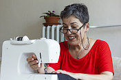 老妇人用缝纫机缝纫