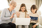 孙辈和祖母一起使用笔记本电脑
