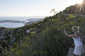 一名女子在地中海日出时拍摄岛屿和大海的照片