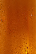 啤酒的背景。冰镇啤酒杯与水珠凝结靠近。