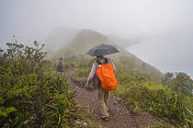 年老的游客沿着厄瓜多尔雾蒙蒙的Cuicocha湖徒步旅行