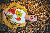 女孩躺在落叶上