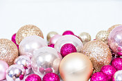 圣诞背景的装饰品在充满活力的粉红色和金色在白色闪闪发光的背景