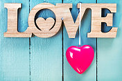 情人节装饰(爱的标志和一颗红心)在一个木制的背景