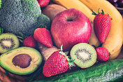 餐桌上的水果和蔬菜，鳄梨，猕猴桃，黄瓜，苹果，草莓，花椰菜和香蕉，靠近