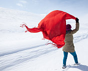 站在雪地上手持红围巾的成年女子