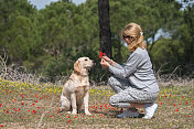 快乐的女人和她的狗一起摘花