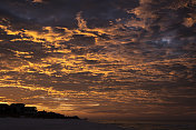戏剧性的日出天空在南沃尔顿海滩