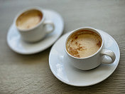 在普拉塔港的一家餐厅的露台上，一张桌子上放着两杯拿铁咖啡的特写。