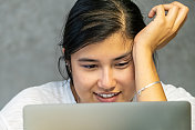 亚洲年轻的大学生看着她的电脑屏幕