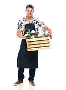 白人男性花商园艺在白色背景穿着围裙和抱盆栽植物