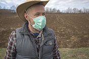 成年农民戴上防护口罩，防止病毒感染