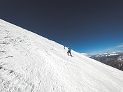 一对登山夫妇在一个阳光明媚的日子攀登一座雪山