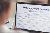 正在网上填写失业救济金申请表的妇女。