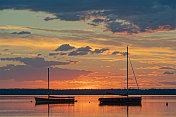 黄昏时湖面上船只的剪影和壮丽的云景