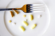 板药胶囊。用叉子装在盘子里的药片和药品。
