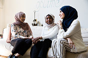 三个穆斯林妇女在家里享受她们的时光