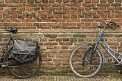 两辆自行车站在砖墙前
