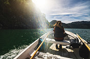 美丽的女人在一艘小渔船上:航行在一个峡湾在挪威
