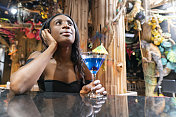 一个非洲裔哥伦比亚女人独自在酒吧喝酒