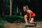 女运动员在森林里伸展身体