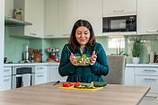 成年妇女在家庭厨房里准备健康食物